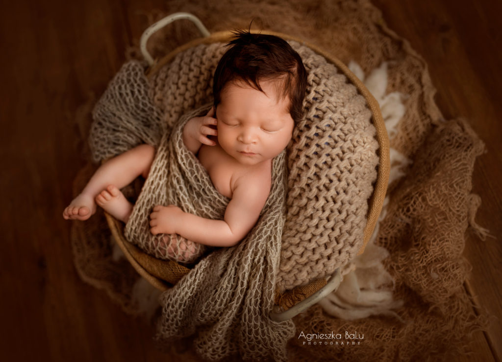Das ausgezeichnete Bild von dem Babyjunge. Das Baby liegt auf die Decke und ist von Tuch bedeckt