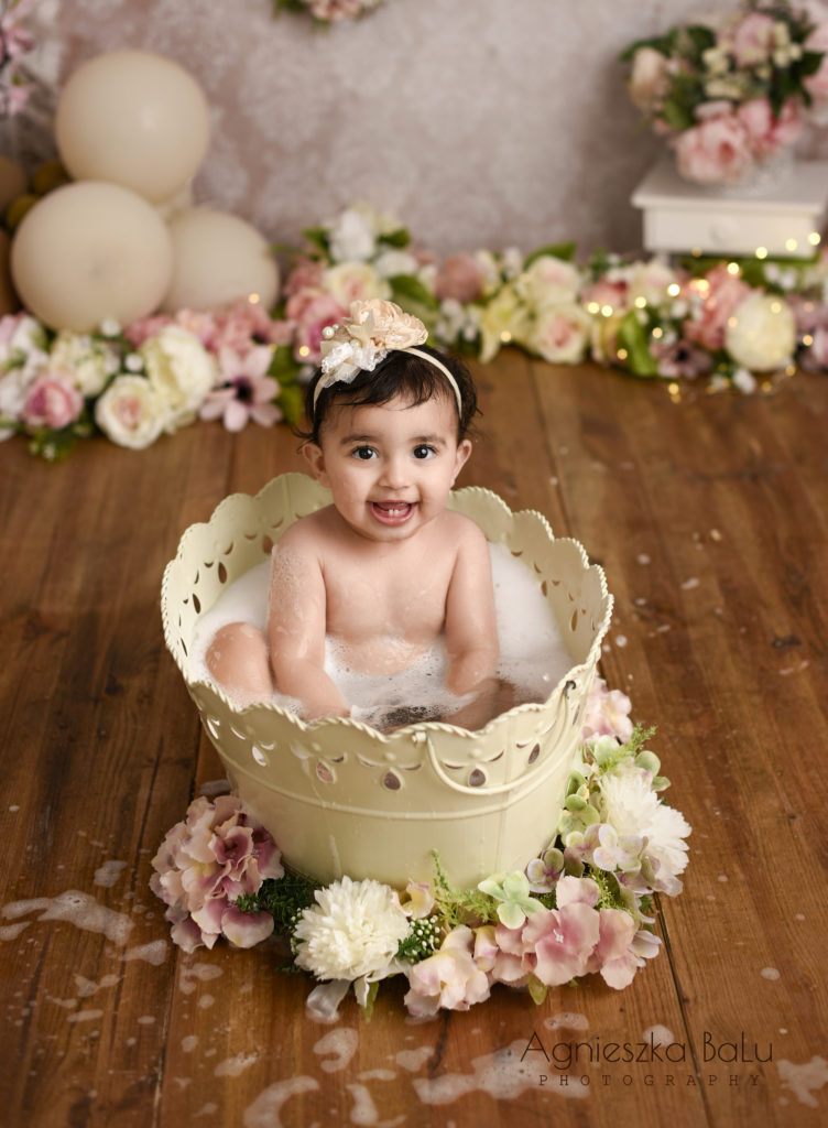 Das Badeshooting nach dem Tortenmatschen. Das Mädchen plantsch in der Badewanne. Umherum befinden sich die Blumen.