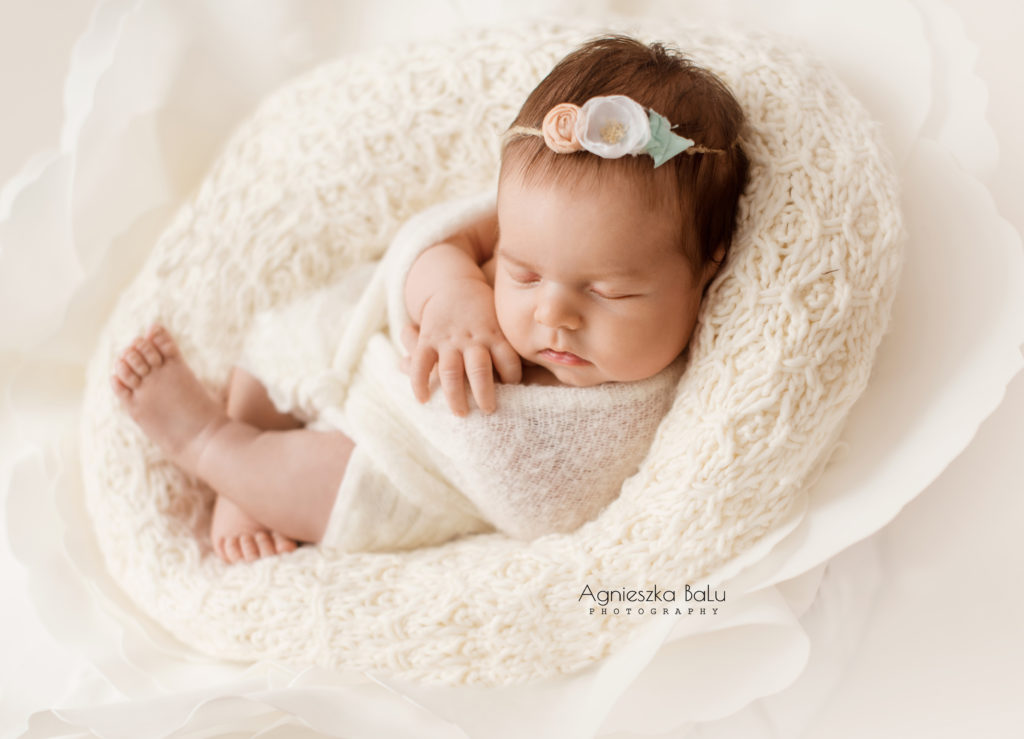 Die natürliche Babyfotografie in Berlin. Das Baby liegt eng gepuckt auf die Decke.