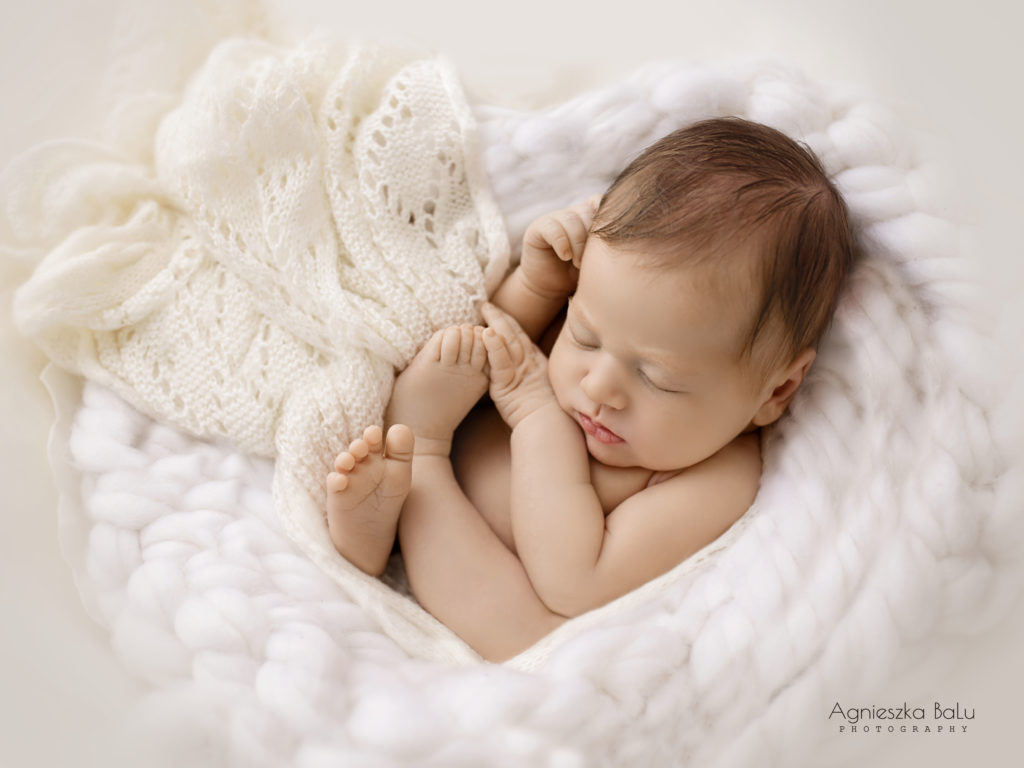 Das ausgezeichnete Bild von der Babyfotografie. Das nackte Bild liegt auf die weißen Decke und schläft.
